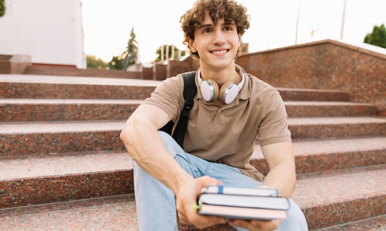 etudiant-masculin-attrayant-est-assis-marches-universite-lit-quelque-chose-qui-se-prepare-aux-examens-min.jpg